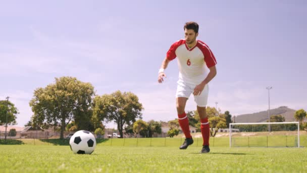 Joueur de football donnant un coup de pied au ballon — Video