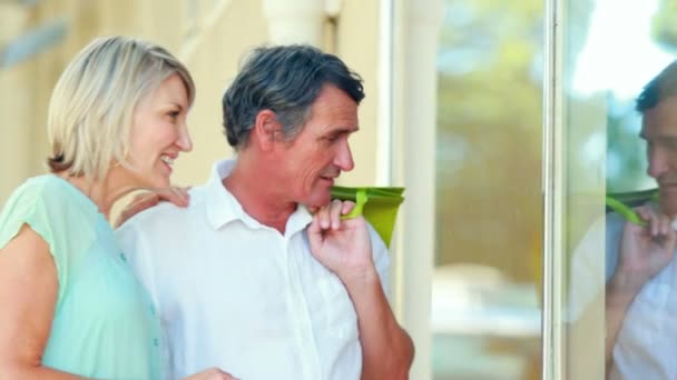 Pareja sonriente mirando a la ventana de visualización — Vídeo de stock