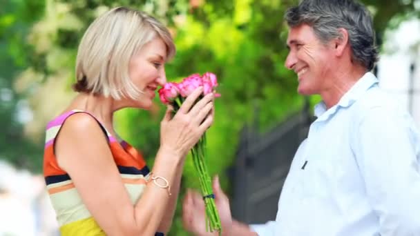 Man die bloemen geeft aan een vrouw — Stockvideo