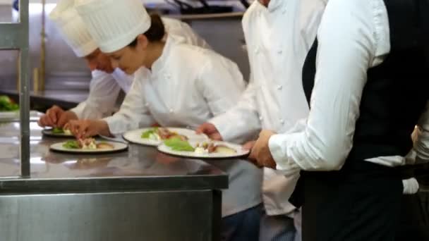 Groep van chef-koks brengen finishing touch — Stockvideo