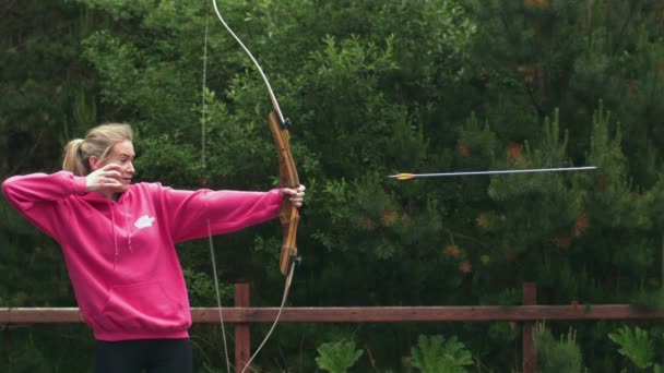 Mulher loira atirando arco e flecha — Vídeo de Stock