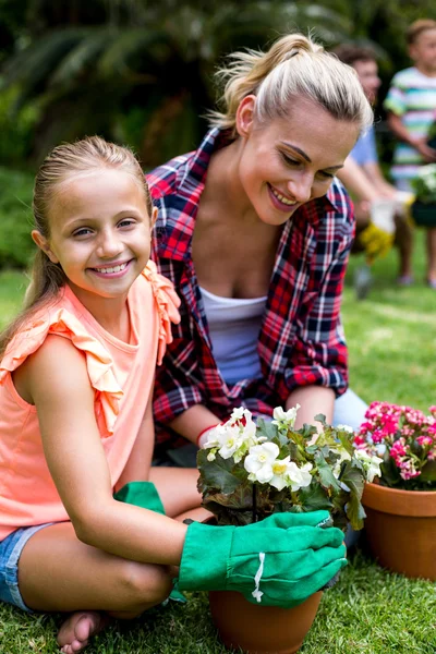 Daughter with mother holding flower pots — Stock Photo, Image