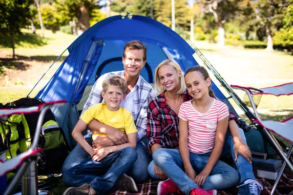 Família feliz sentada na frente da tenda — Fotografia de Stock
