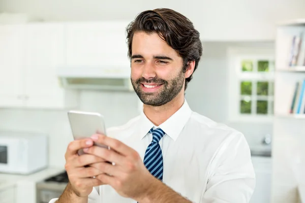 Homem de negócios usando celular na cozinha — Fotografia de Stock