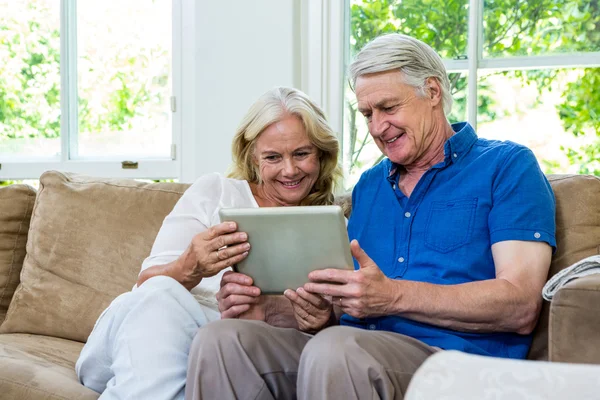 Seniorenpaar nutzt Tablet zu Hause — Stockfoto