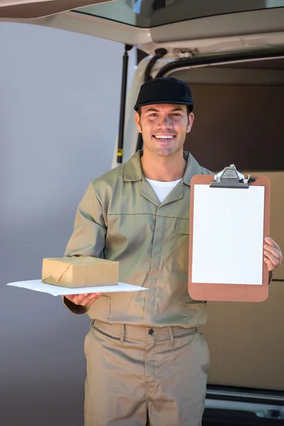 Feliz entrega hombre sosteniendo caja de cartón y portapapeles — Foto de Stock