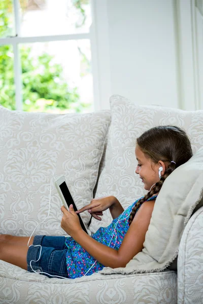 Girl using digital tablet on sofa — Stock Photo, Image