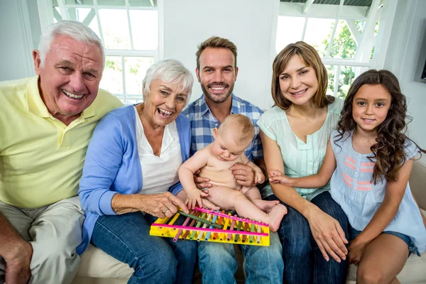 Familj sitter på soffan hemma — Stockfoto