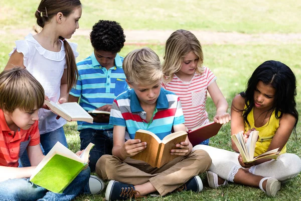 Niños leyendo libro en el parque — Foto de Stock