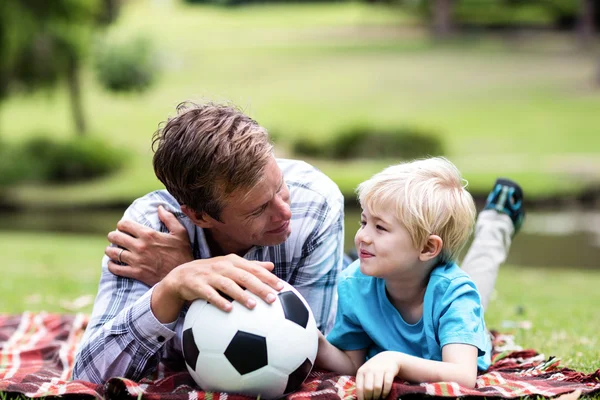 Vader en zoon liggen in park — Stockfoto