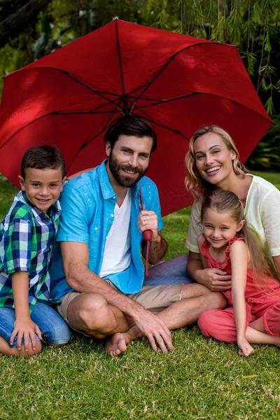 Bahçesinde şemsiye ile oturan aile — Stok fotoğraf