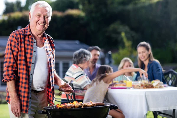 Starší muž na grilu — Stock fotografie