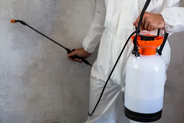 Manual worker using spray on wall — Stock Photo, Image