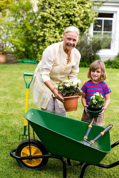 Grandmother with boy holding flower pots — Stock Photo, Image