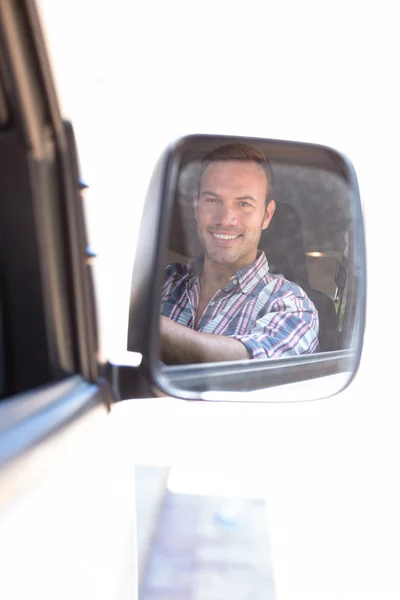 Fiatal férfi vezetés a tükörképét visszapillantó tükör — Stock Fotó