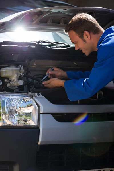 Mecánico examinando el coche — Foto de Stock