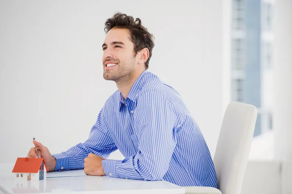 Cheerful businessman with model house — Stock Photo, Image