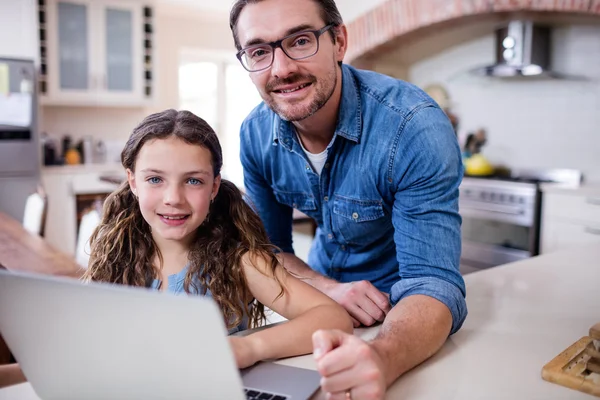 Father and daughter using laptop in kitchen — Stock Photo, Image