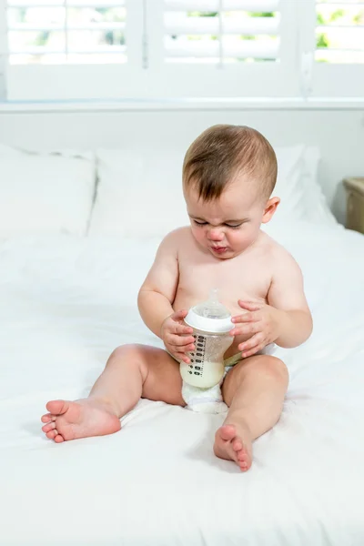 Junge sitzt mit Milchflasche — Stockfoto