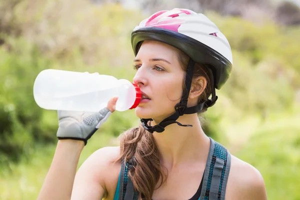 Woman drinking water and wearing helmet — Stock Photo, Image