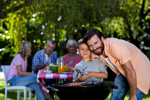 Padre con hijo por barbacoa parrilla — Foto de Stock