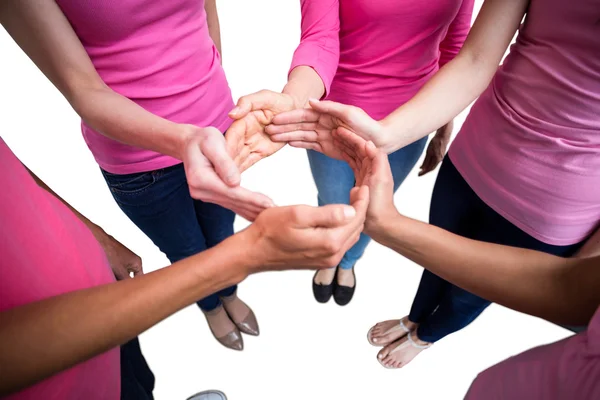 Women in pink outfits joining in circle — Stock Photo, Image