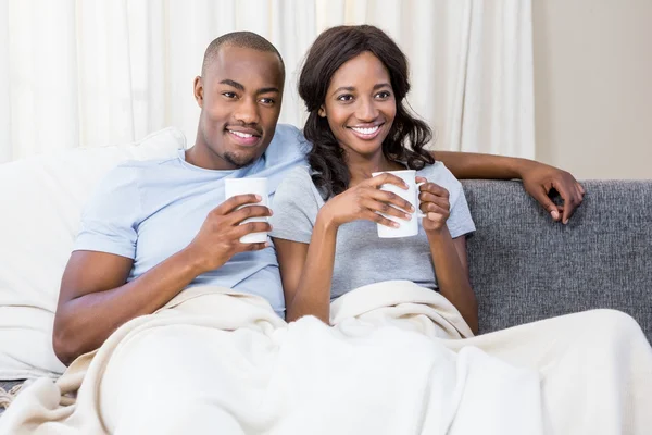 Jeune couple relaxant sur canapé — Photo