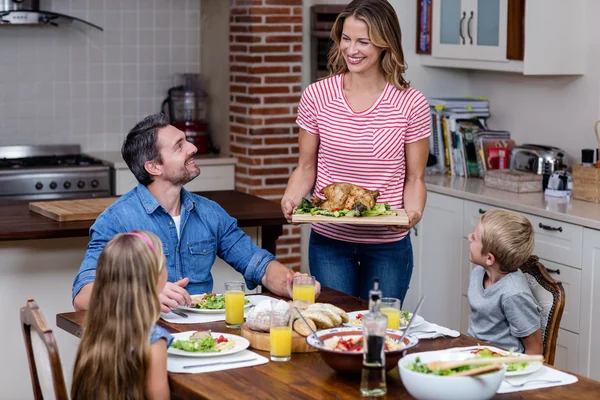 Mujer sirviendo comida a la familia en la cocina —  Fotos de Stock