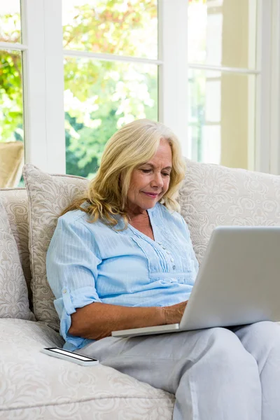 Kvinna som använder laptop hemma — Stockfoto