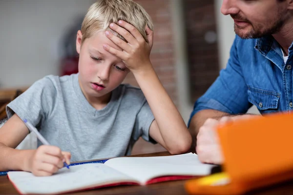 Ojciec pomagający synowi w zadaniach domowych — Zdjęcie stockowe
