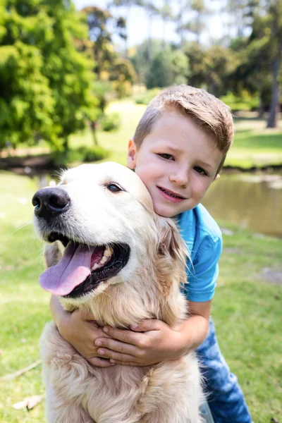 Boy with pet dog in park Stock Picture