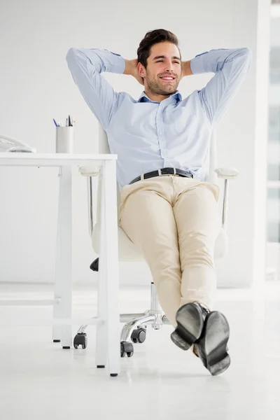 Businessman sitting with hands behind head — Stock Photo, Image