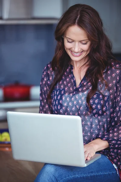 Kobieta korzystająca z laptopa w kuchni — Zdjęcie stockowe