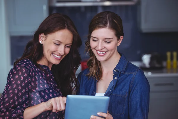 Vrouwen met behulp van digitale tablet in keuken — Stockfoto