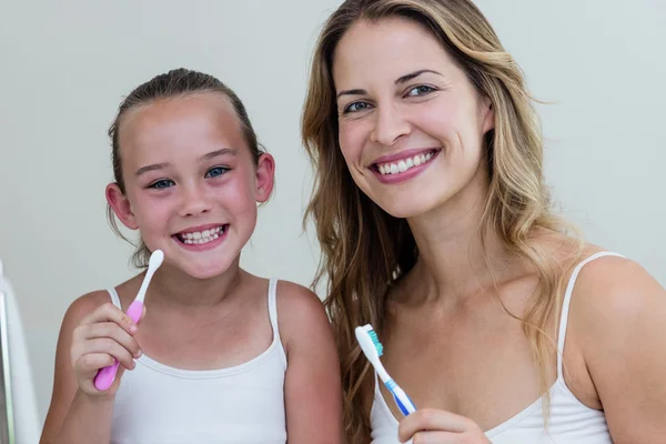 Diş fırçası tutan anne ve kızı — Stok fotoğraf