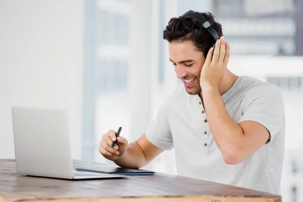 man using pen tablet and laptop