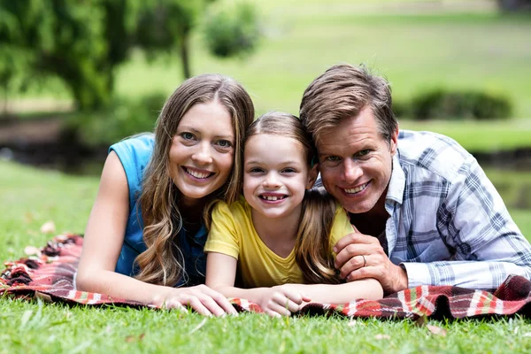 Föräldrar och dotter ligga i park — Stockfoto