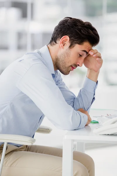 Frustrierter Geschäftsmann sitzt auf Schreibtisch — Stockfoto