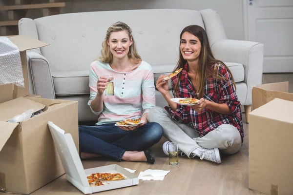 Женщины с пиццей в новом доме — стоковое фото