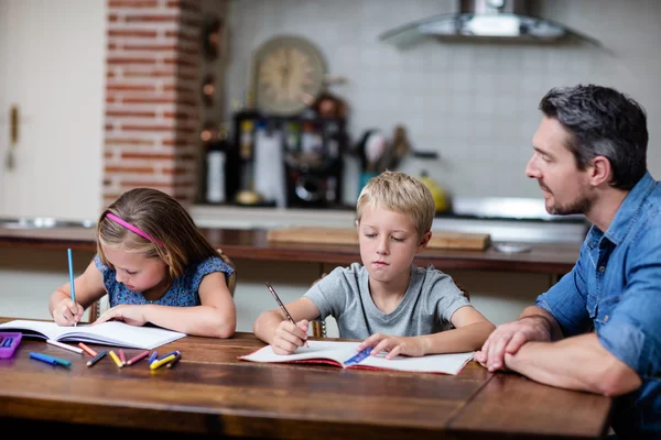 Vader helpen kinderen met huiswerk — Stockfoto