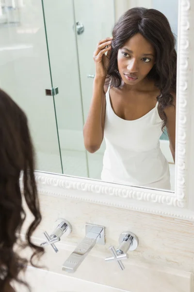 Mujer mirándose en el espejo — Foto de Stock