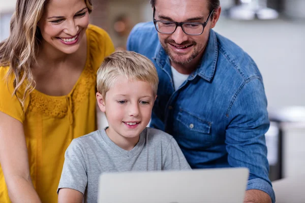 Pais e filho usando laptop na cozinha — Fotografia de Stock