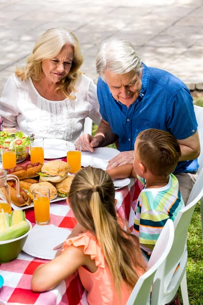 Grand chidren con abuelos almorzando — Foto de Stock