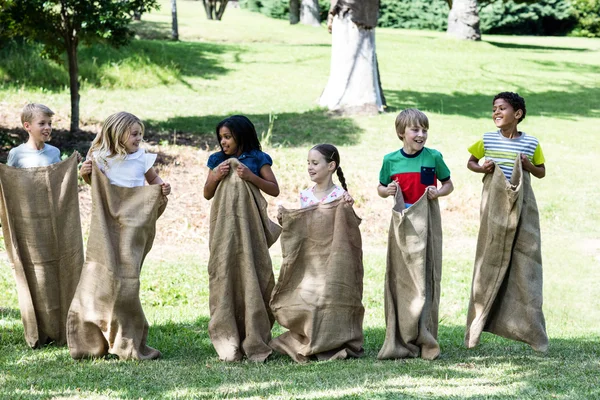 Дети участвуют в забеге на мешок в парке — стоковое фото