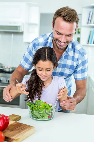 Vater hilft Tochter bei der Zubereitung von Salat — Stockfoto