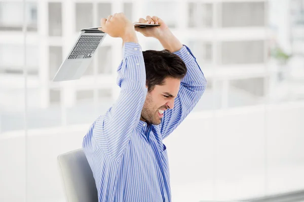 Frustrated businessman throwing laptop — Stock Photo, Image