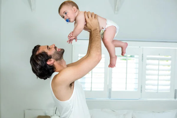 Pai brincando com filho pela cama — Fotografia de Stock