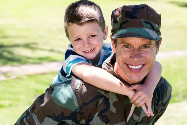 Soldier giving piggyback to son — Stock Photo, Image