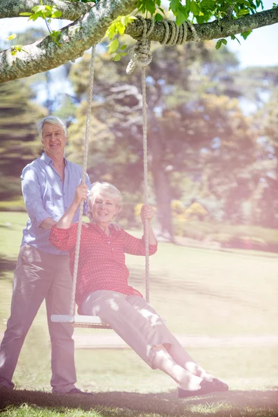 Uomo spingendo partner su swing — Foto Stock