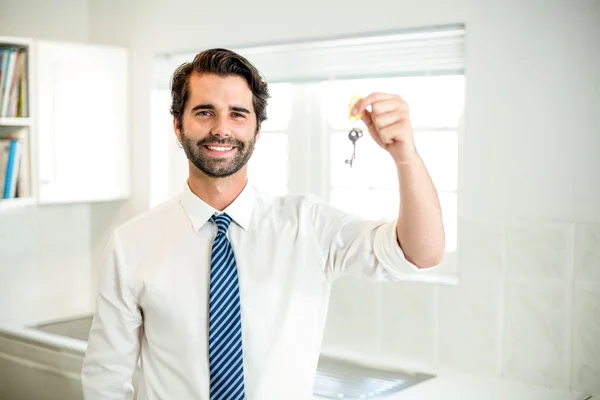 Бізнесмен тримає ключ будинку вдома — стокове фото